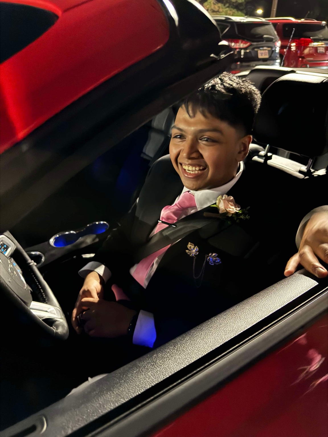 Seratul Ambia smiling in a suit and pink tie